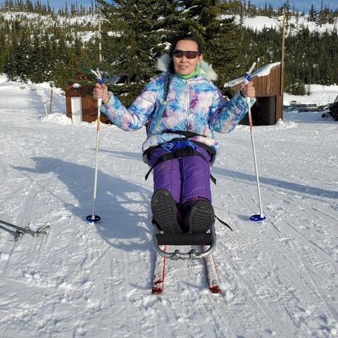 Me with my ski poles on a Nordic sitski on the mountain.