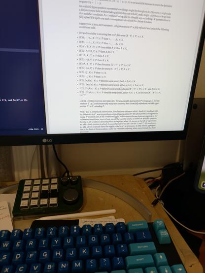 A screen containing a series of clauses in the proof theory of quantified modal logic, above a mechanical keyboard with dark blue and light blue keycaps.