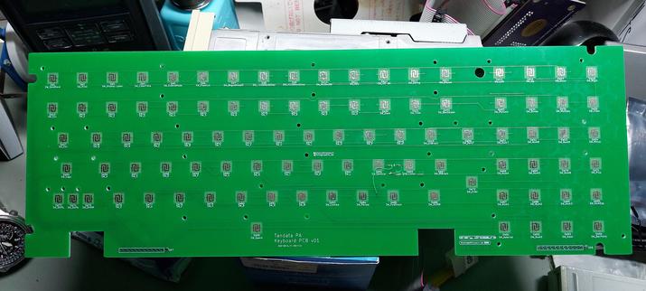 A green PCB for a terminal keyboard. It's about 40cm long and 13cm wide.
It's scattered with numerous contact pads for key switches.