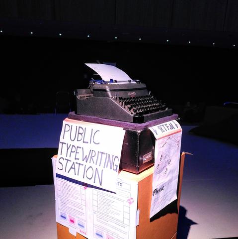 A typewriter on a pedestal, with "PUBLIC TYPEWRITING STATION" written on the side in large letters.