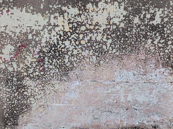 Spattered, worn paint on a concrete surface
