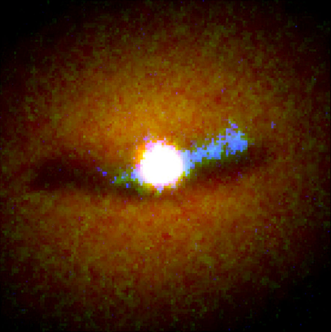 Hubble composite image of NGC 6251. The pixelated image is primarily orange-brown with a bright white area in the center. Mostly to the right side of the image is a tail of ultraviolet light (color-coded blue).