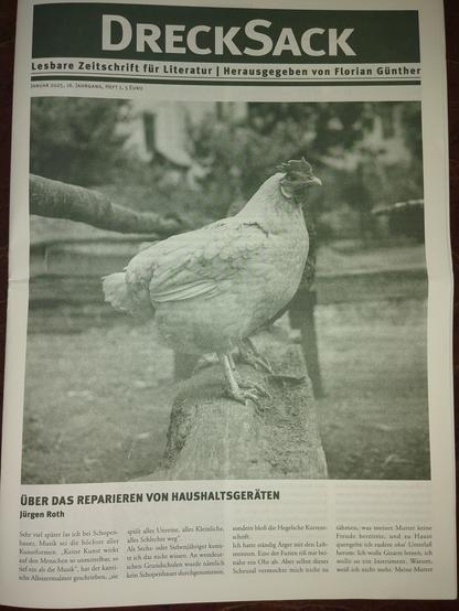Titelseite der Literaturzeitung Drecksack. Großes Foto eines auf einem Baumstamm sitzenden Hühnchens. Darunter der Beginn eines Artikels mit dem Titel 'Über das Reparieren von Haushaltsgeräten'