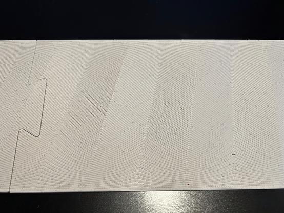 Close-up photo of part of the ramp shows the herringbone pattern in more detail.  Near the top and bottom of the surface, the stripes nearly horizontal.  In the middle, they are about 45 degrees.  They are noticeably curved near the edges.
