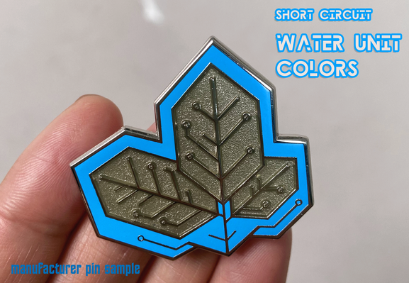 Handing holding a hybrid enamel pin of leaves designed to look like a printed circuit board (PCB) in blue and silver.