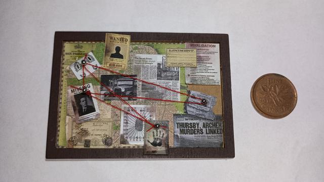 A close-up of a tiny recreation of an investigative cork board: it is covered in newspaper clippings and documents.  Small pins are stuck in some of the papers, and red thread is strung between them to connect them. It is only seven centimeters wide, and a penny is presented next to it for context.