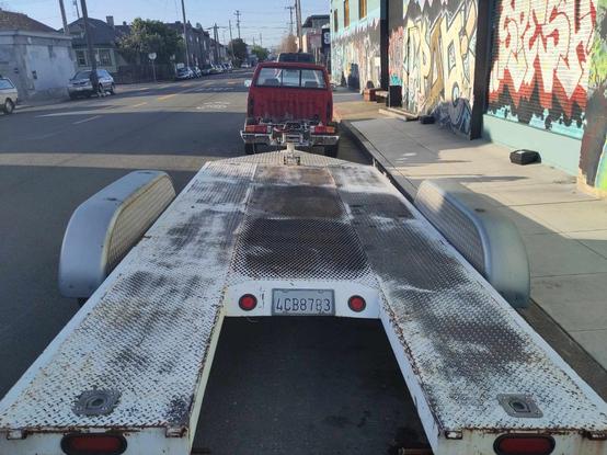 View from the rear of the car hauler, with tiny red truck in the distance.