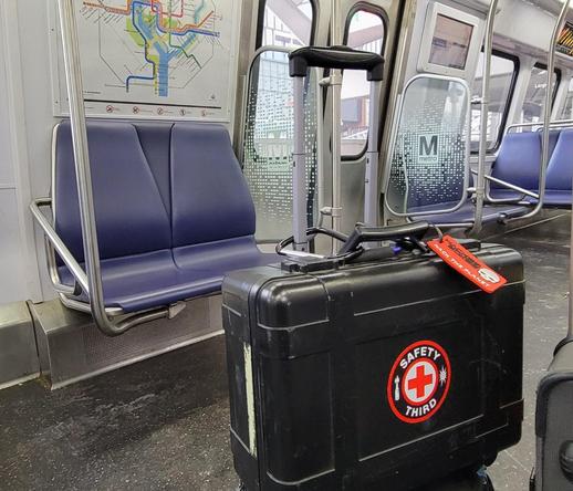 pelican case with a large Safety Third sticker on a commuter train