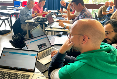 Personnes en réflexion devant des ordinateurs portables lors d'une formation.