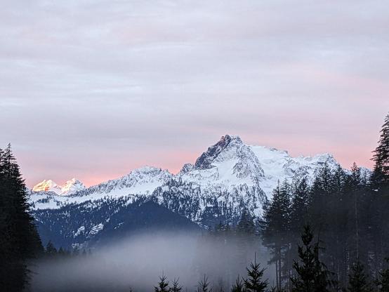 Snow covered Whitehorse mountain side lit by the dawn.