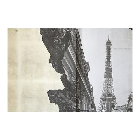 Une photo noir et blanc de la tour Eiffel collée sur un mur, en partie déchirée sur le côté gauche de l'image.