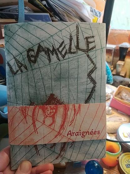 Couverture du fanzine La Gamelle sur les araignées (impression au Tetra pack d'une araignée dans une Toile avec un bandeau rouge)