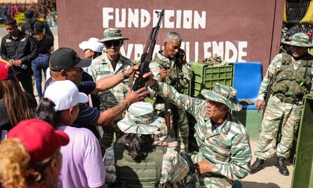 Miembros de la Milicia Bolivariana armando a simpatizantes de Nicolás Maduro antes de una marcha en su honor, el 7 de enero de 2025, en Caracas. (JESUS VARGAS / Getty Images)