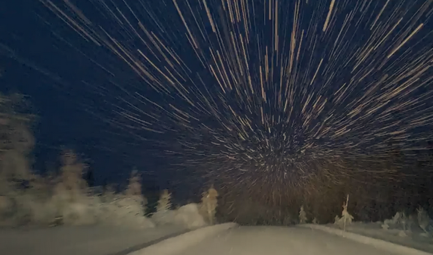 Color image from the viewpoint of a car driving through snow falling.