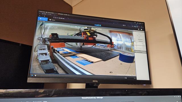 A photo of a LCD montor showing a CCTV image of a CNC machine.