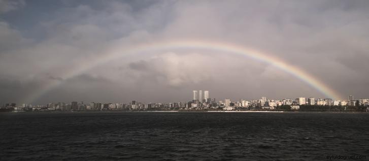 a large rainbow above a city coastline