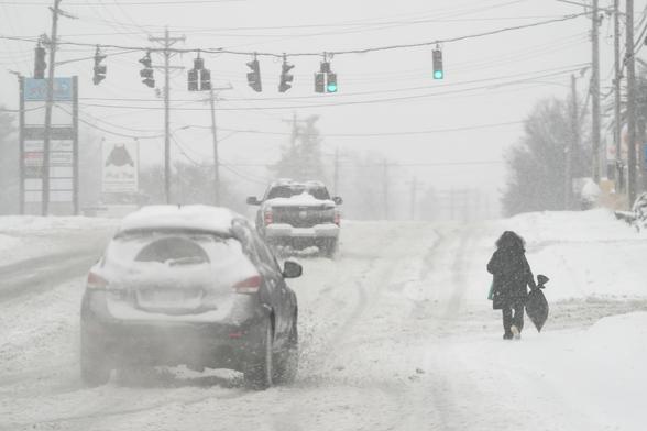 photo - heavy snow falls as a person walks along U.S. Route 42 in Florence, Ky., Monday, Jan. 6, 2025.