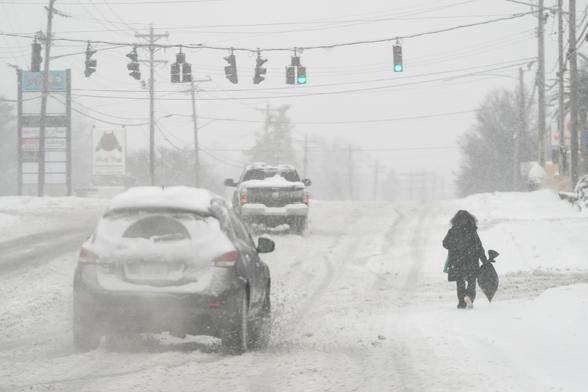 photo - heavy snow falls as a person walks along U.S. Route 42 in Florence, Ky., Monday, Jan. 6, 2025.