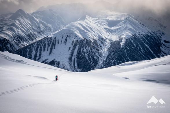 two people on a ski tour in a wintery landscape in the Swiss Alps.