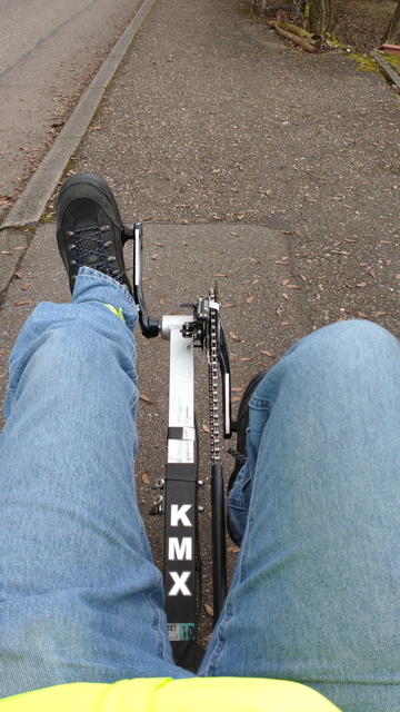 Rider's view on the KMX recumbent recumbent trike. I'm wearing blue jeans and yellow hi-viz jacket.