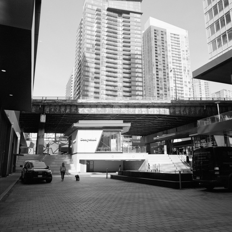 New development has grown all around, and even under, an ageing and decaying elevated highway, clean modern lines contrasting with the corroding metal and crumbling concrete on the roadway.