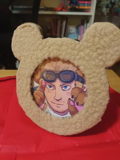 Photo of a drawing of Cid Highwind (Final Fantasy) in a fluffy teddy bear frame