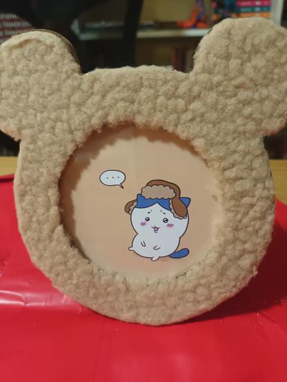 Photo of a drawing of Hachiware (Chiikawa) in a fluffy teddy bear frame