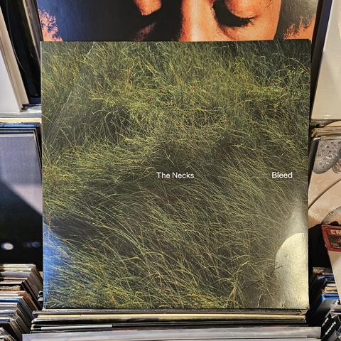 Album cover features a photograph of long green grass, seen from above.