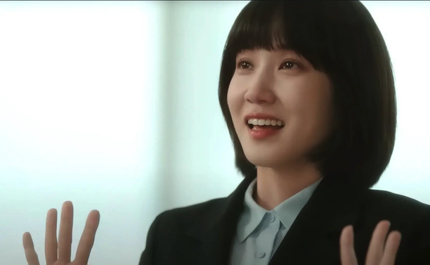 Park Eun Bin, wearing a dark suit with her hands held up, fingers splayed in the 2022 South Korean drama "Extraordinary Attorney Woo."