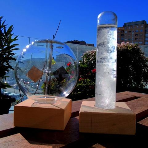 El radiómetro de Crookes con sus paletas que cierran por la luz del sol en su esfera de vidrio junto al tubo con una disolución que cristaliza (alcanfor) que utilizó el capitán del Beagle. Al fondo el cielo azul de este mediodía de enero.