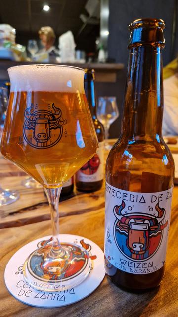 Glas en flesje van de Weizen con Naranja van Cerveceria de Zarra.