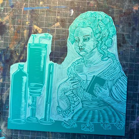 My mostly carved green vinyl Lino block of Claudine Picardet in last 17th century wig with ringlets and dress, holding a book behind a table with a collection of minerals and scientific glassware for chemistry experiments.