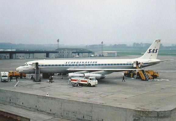 Plane is parked on the tarmac awaiting passengers under grey skies.