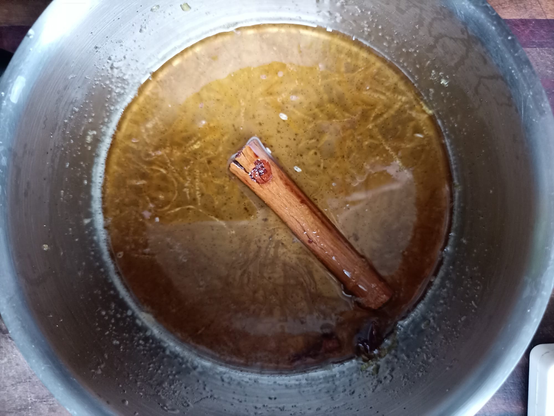 In einem kleinen Topf der Sirup mit einer Zimtstange