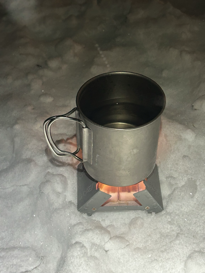 Water being boiled on a small camping stove.