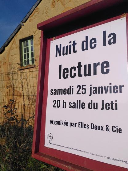 Une manchette sur son panneau d'affichage devant une façade de maison en terre.