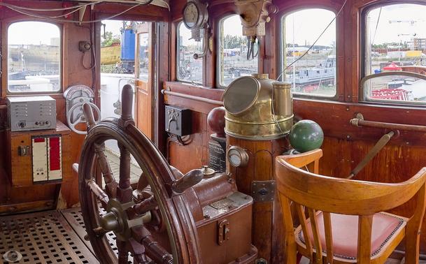 Cabin of the West-Hinder, a light ship that operated well into thee 1990s. Left front is the wheel. At the right the chair/stool of the captain. Some ancient instruments. Through the windows the harbour of Antwerp can be seen.