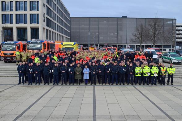 BM Nancy Faeser gemeinsam mit Mitarbeitenden verschiedenster Behörden (Polizeien, Flughafenfeuerwehr, Flughafensicherheit, Zoll und Bundeswehr) sowie Vertreter des Sicherheitsdienstleisters Securitas auf dem Willy-Brandt-Platz vor dem Terminal 1.