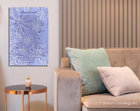 Periwinkle daisies with the Desiderata poem over it by artist Sharon Cummings.  In a furniture setting.