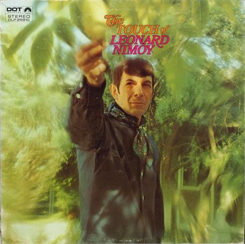 Guy in black shirt (Leonard Nimoy) reaches for a leaf on tree. Surrounded by many more green blurry trees or shrubs. Record cover with some signature in the upper left corner and title »The Touch of Leonard Nimoy«