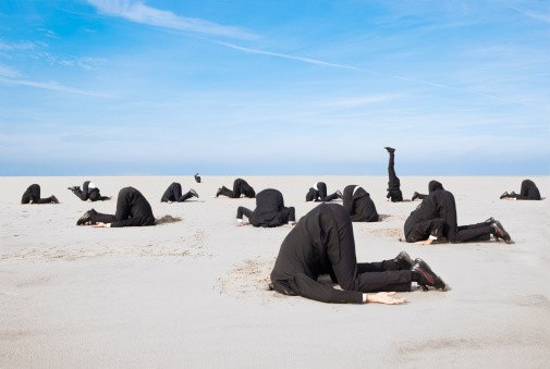 People in suits putting their heads in the sand