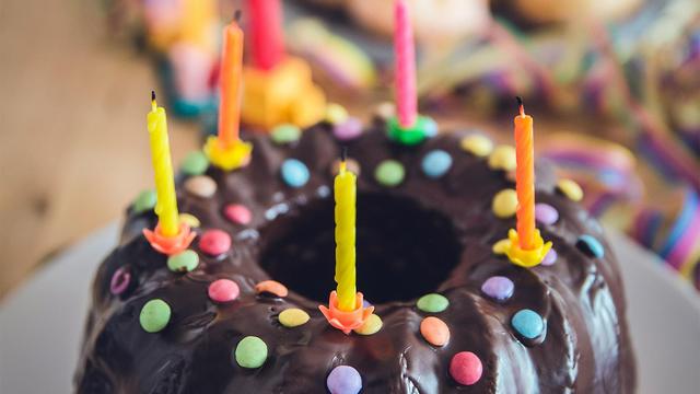 Birthday cake with chocolate icing and candles on top.