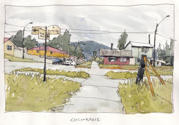 A town called Cochrane in Patagonia, Chile. A crossing, some ramshackle houses, a road sign, distant mountains. A rainy, overcast day. But still, lovely colours.