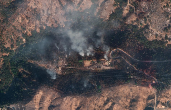 Smoke rising over a canyon, just smoldering