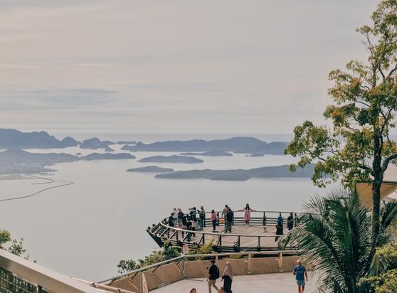 Langkawi, Malaysia. A picture of a platform high up a mountain. There are people on the platform overlooking the ocean.