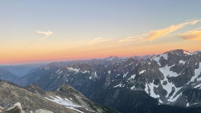 Rows of mountains in the distance. A vibrant blue and gold sunset is above