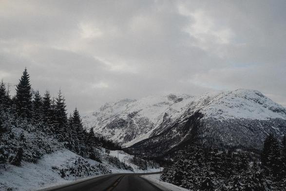 A zig zag road in the middle of the snow covered mountains.