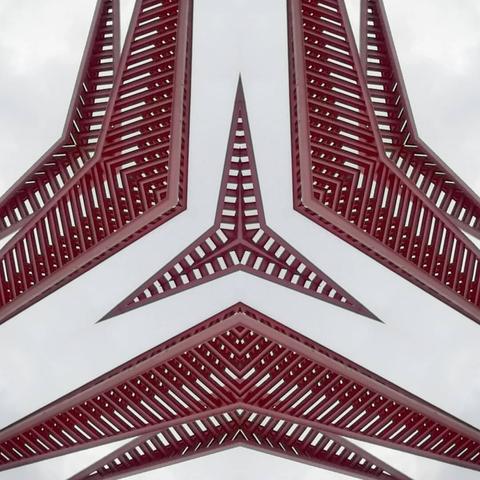 Triangle shaped kaleidospic pattern of a pink steel structure. Cloudy background