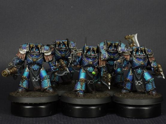 This image shows a squad of 5 Lernean Terminators from the horus heresy, they're clad in metallic blue terminator armour.