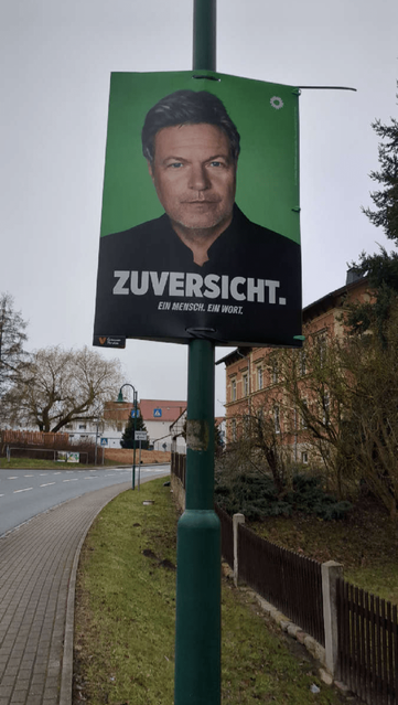 Ein Wahlplakat mit Robert Habeck hängt an einer Laterne.